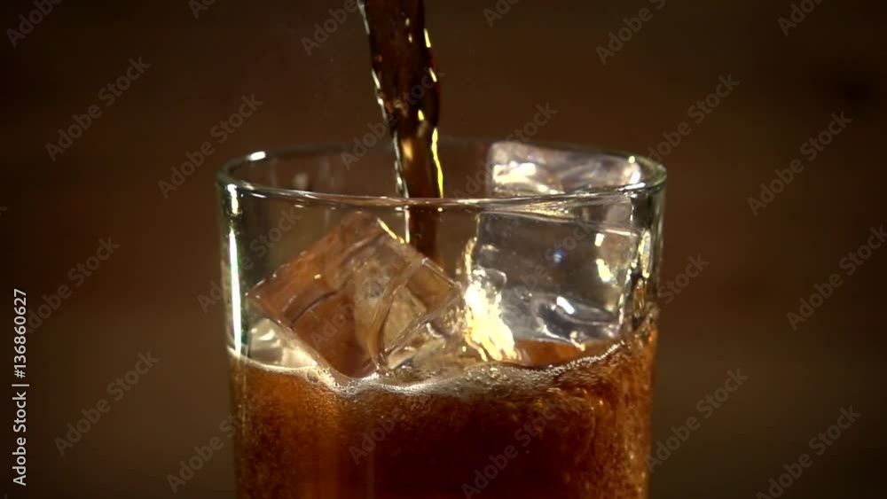 Cola poured into glass with ice. Cola and ice in glass. Bubble float. Slow motion 240 fps.Slowmo. Cola poured into glass with ice. Cola and ice in glass. Bubble float. Slow motion 240 fps.Slowmo.