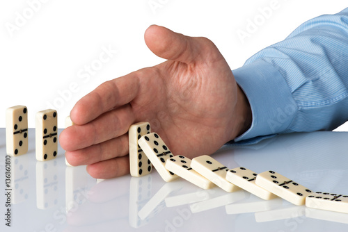 Fotografie hand stopping domino falling sequence