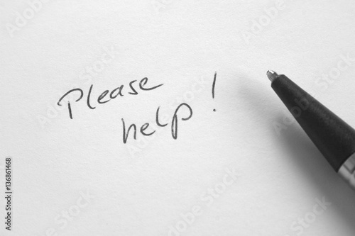 Handwritten phrase 'Please Help' on white paper