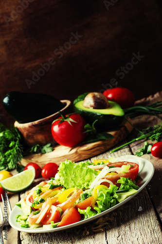 Salad with salted salmon and vegetables. Vintage wood background