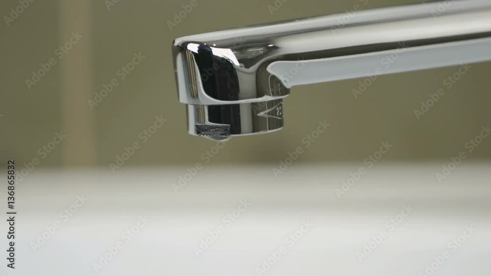 Water dripping from chrome-plated faucet. Close-up Water dripping from chrome-plated faucet. Close-up