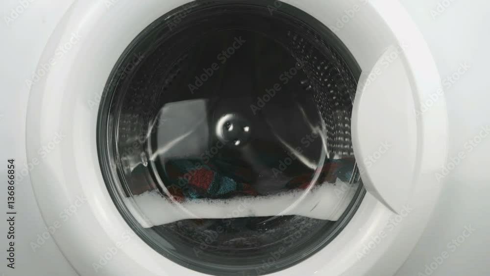 Home electronics. Internal view of a washing machine drum during wash program. Close-up Home electronics. Internal view of a washing machine drum during wash program. Close-up