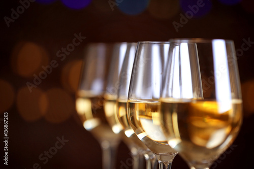 Glasses of wine in a row on bokeh background