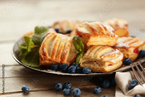 Sweet tasty pastries with bilberries on plate, closeup