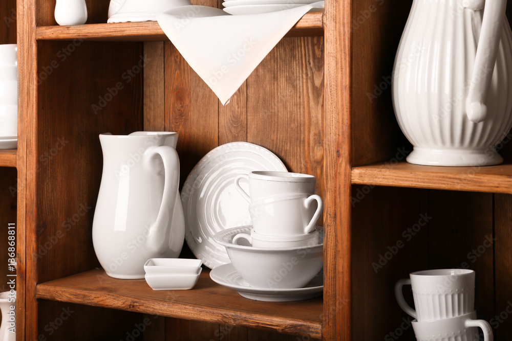 Wooden shelves with white rustic dinnerware Wooden shelves with white rustic dinnerware