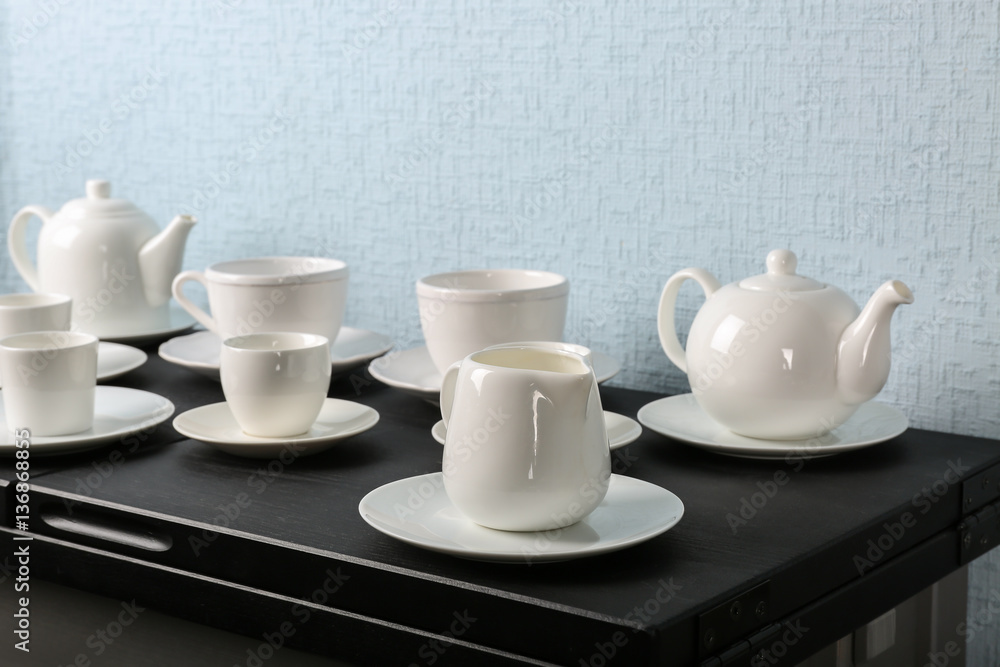 Simple white tea set on black wooden table Simple white tea set on black wooden table