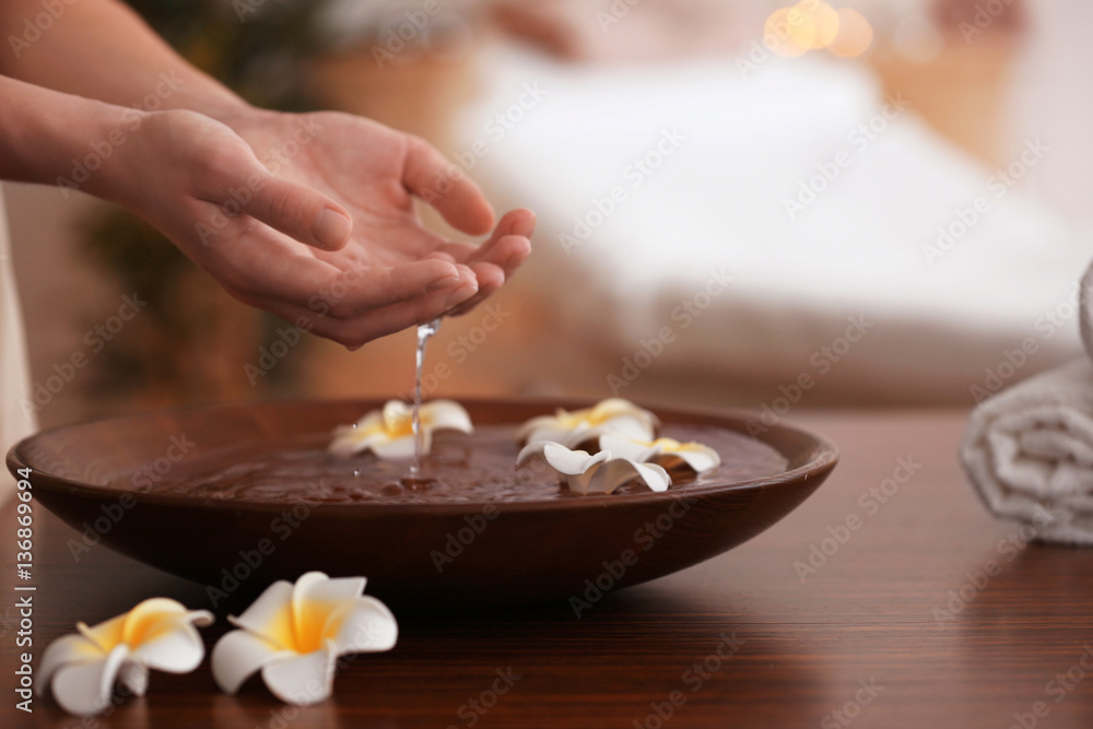 Spa concept. Female hands with bowl and exotic flowers Spa concept. Female hands with bowl and exotic flowers