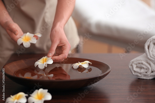 Spa concept. Female hands with bowl and exotic flowers