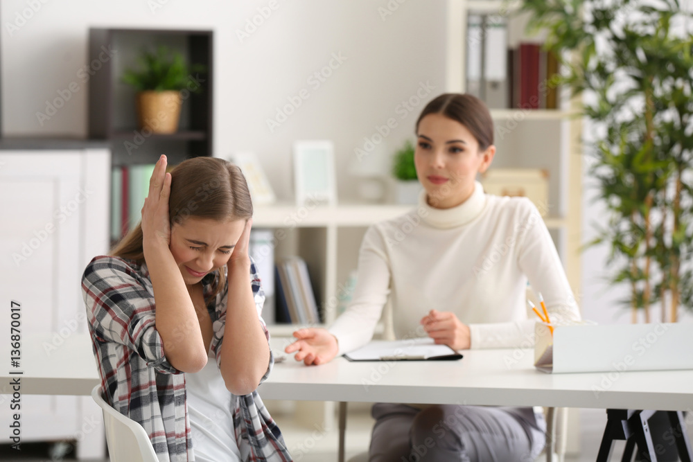 Young female psychologist working with teenager girl in office Young female psychologist working with teenager girl in office