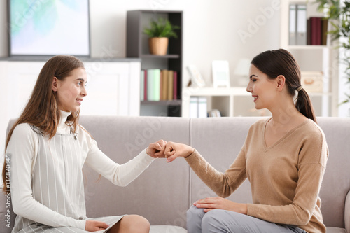 Young female psychologist working with teenager girl in office