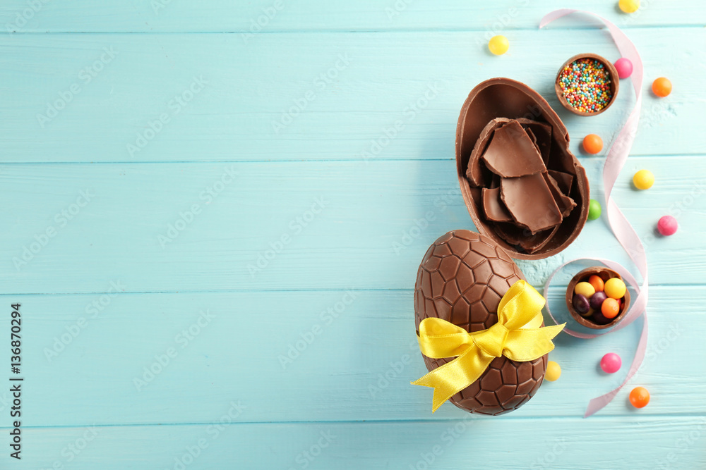 Fototapeta premium Easter composition with chocolate eggs on color wooden background, space for text