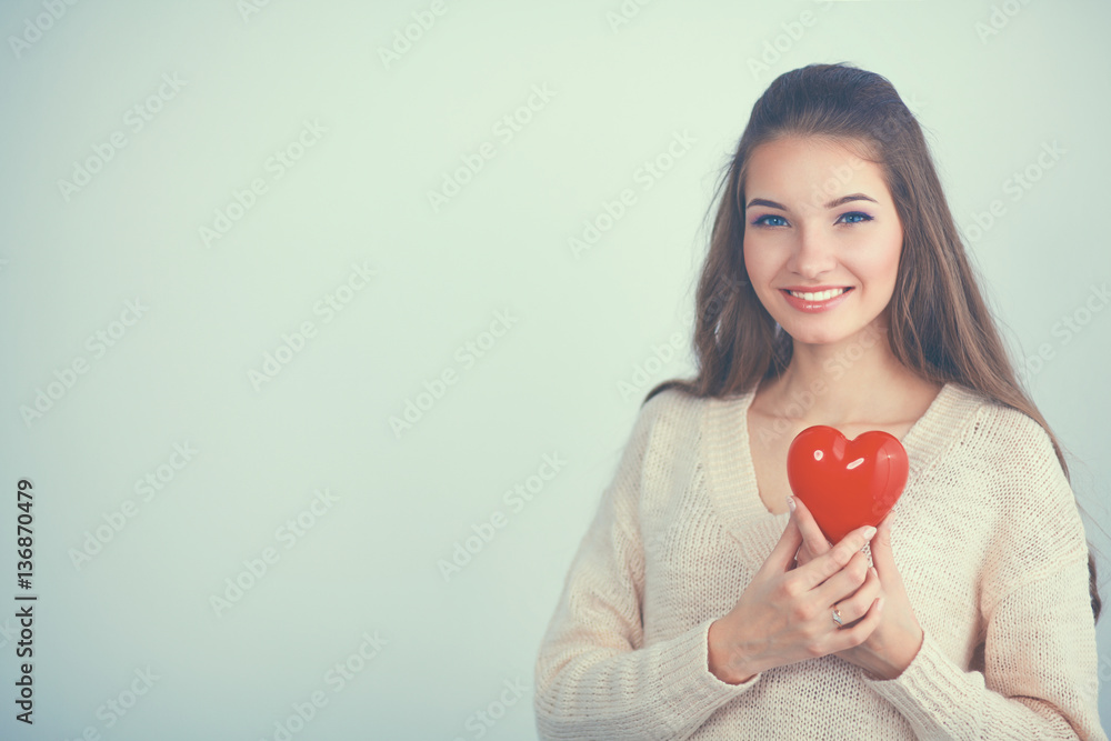 Beautiful woman hold red hear, isolated on gray background Beautiful woman hold red hear, isolated on gray background