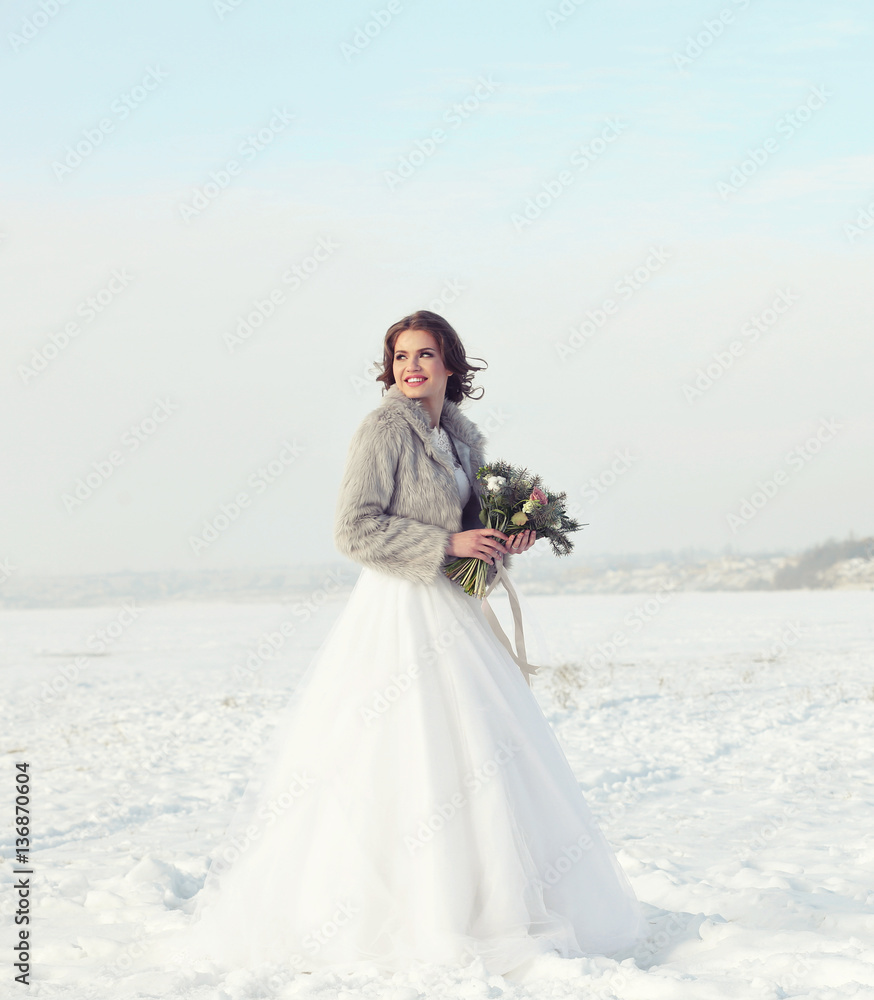 Beautiful bride with bouquet outdoors on winter day