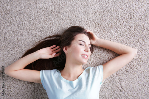 Happy young woman lying on ...