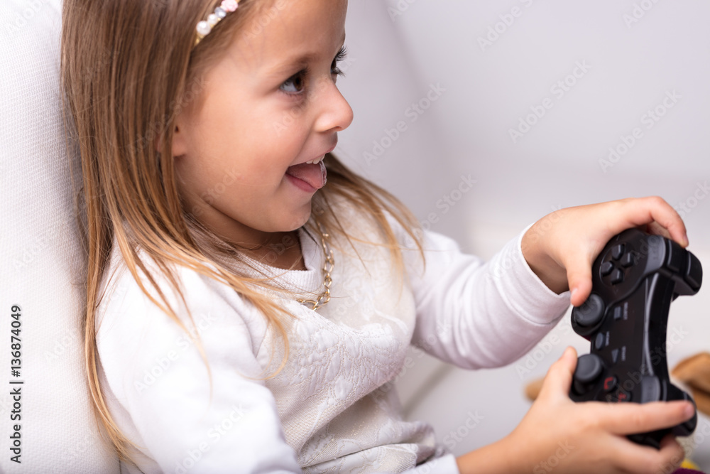 Excited little girl having fun playing video games Excited little girl having fun playing video games