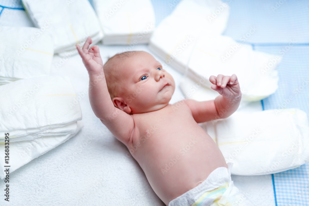 newborn baby on changing table with diapers newborn baby on changing table with diapers