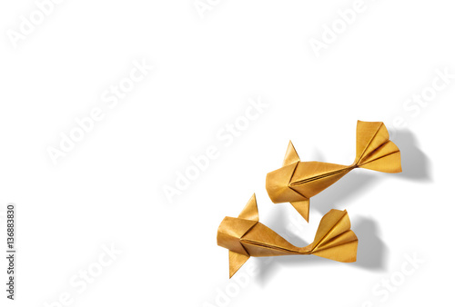 Handmade paper craft gold color origami koi carp fish on white background with empty space. 