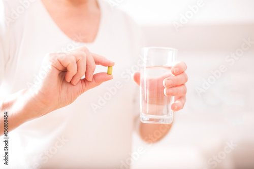 Frau hält Tablette mit Wasserglas