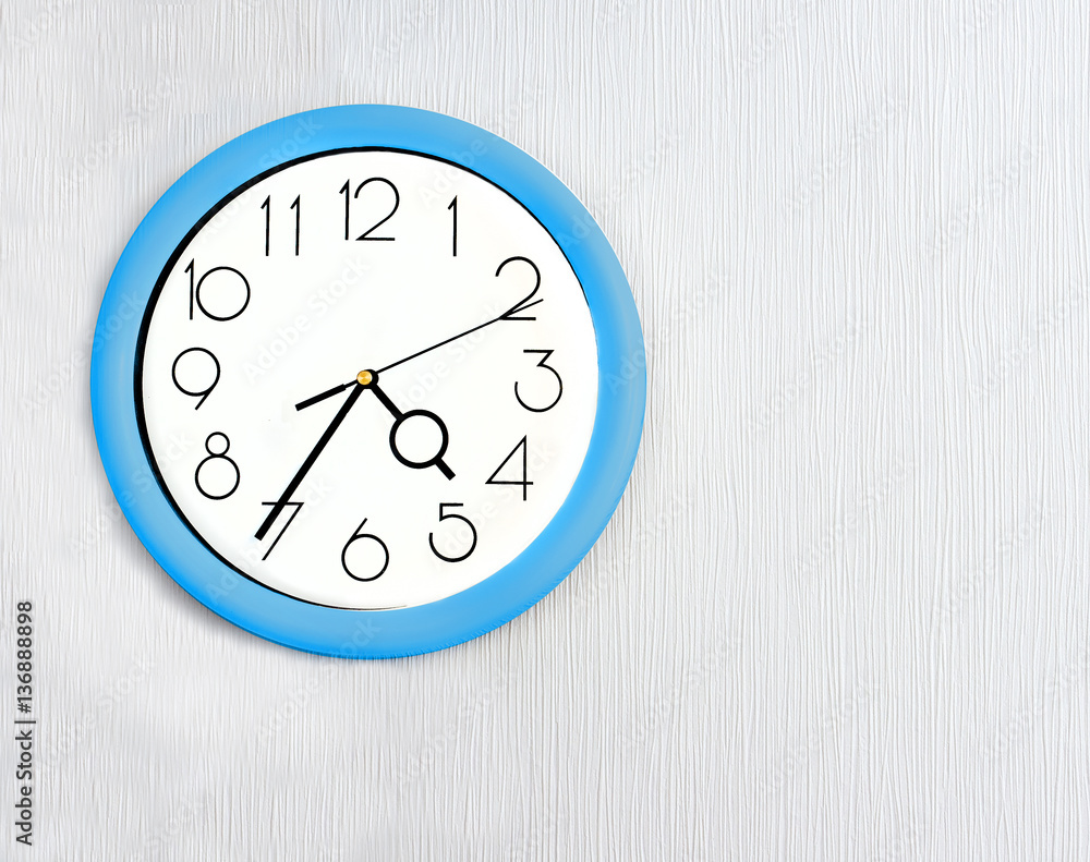 Blue wall clock hanging on white wall Blue wall clock hanging on white wall