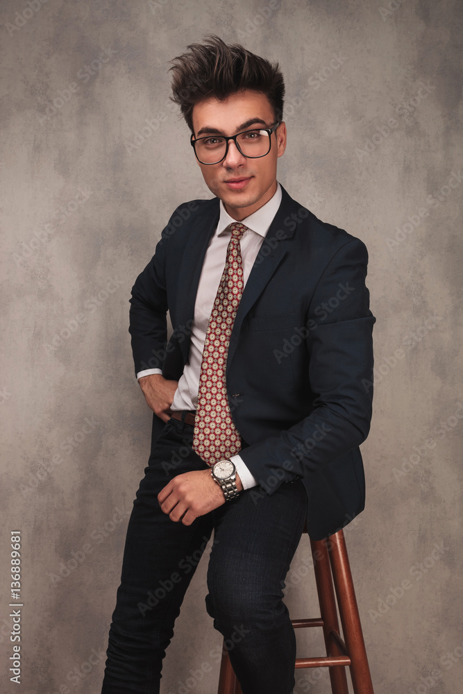 young elegant business man sitting on a stool young elegant business man sitting on a stool