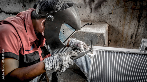 Closeup of man wearing mask Welding steel structures and bright sparks in a workshop