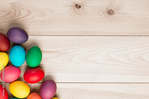 a bunch of Easter eggs in the corner and a wooden background for