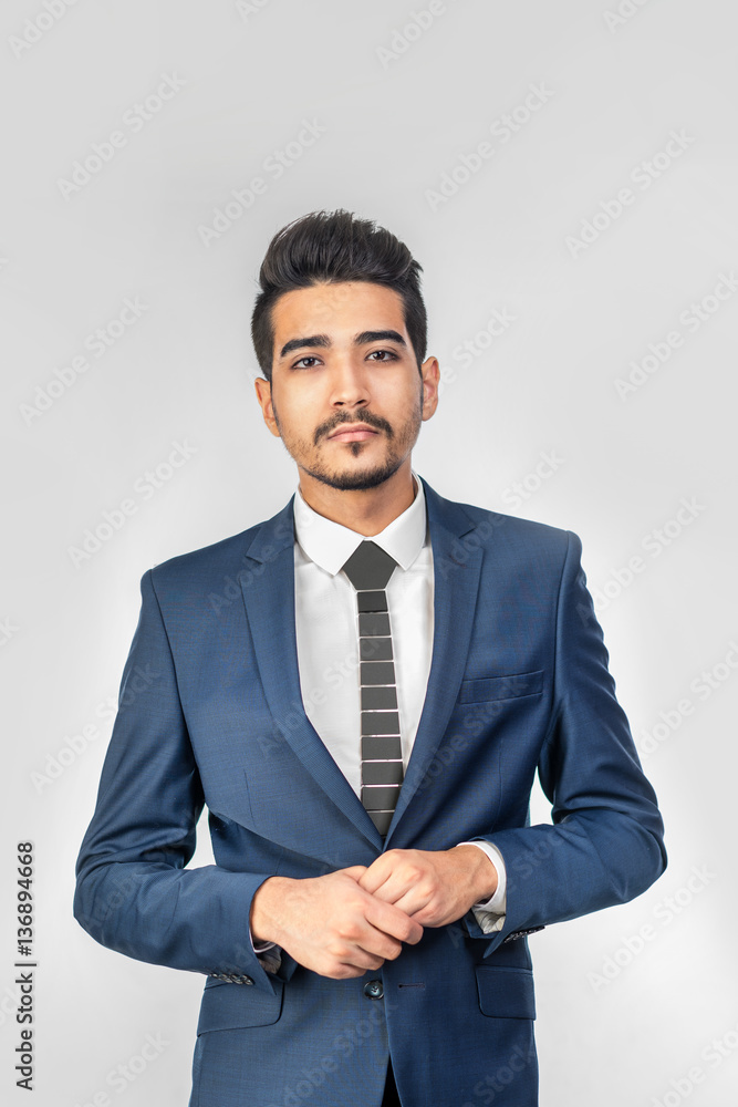 Young attractive man in a blue suit on a gray background. Isolated Young attractive man in a blue suit on a gray background. Isolated