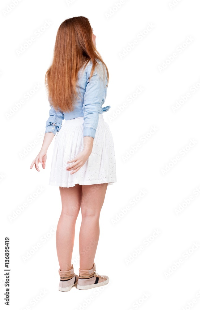 Back view of young redhead woman pointing at wall. beautiful girl in dress. Rear view people collection. backside view of person. Isolated over white background. Back view of young redhead woman pointing at wall. beautiful girl in dress. Rear view people collection. backside view of person. Isolated over white background.