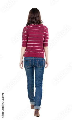 back view of walking woman in striped sweater.