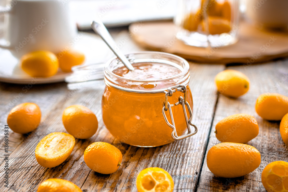 kumquat on plate and jam in jar at wooden table kumquat on plate and jam in jar at wooden table