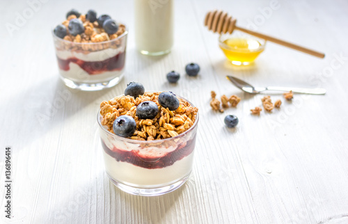 Fitness breakfast with muesli, honey and milk on white table