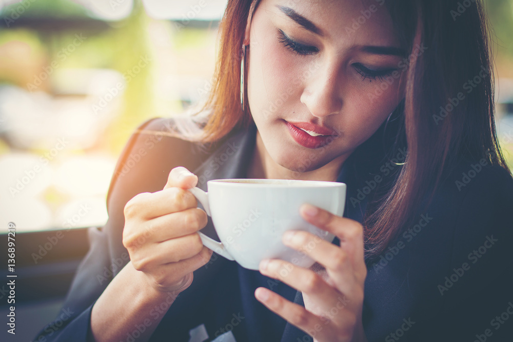 Businesswoman thinking plan all about money return on investment on chair in office whith notebook and drink coffee Businesswoman thinking plan all about money return on investment on chair in office whith notebook and drink coffee