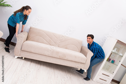 Wife and husband moving sofa couch © Elnur