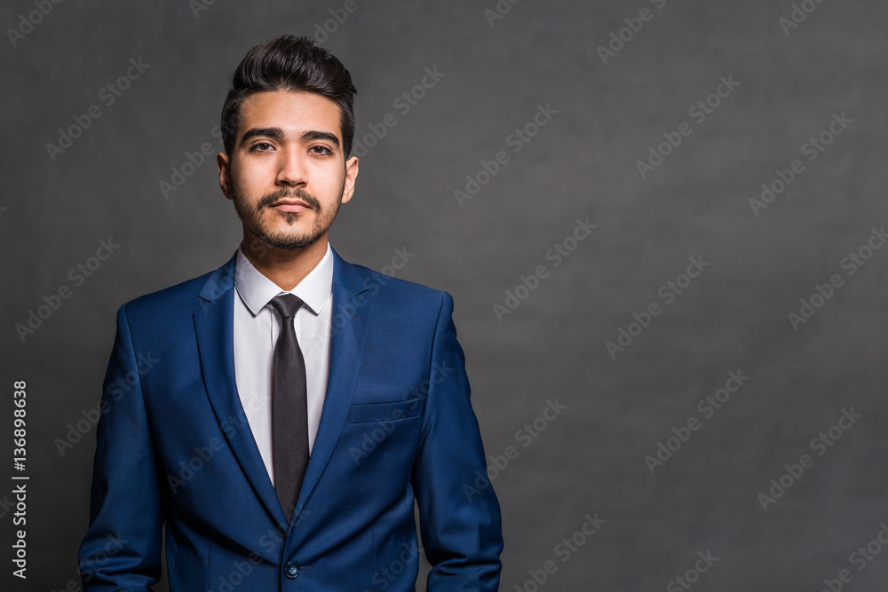Young attractive man in a blue suit on a gray background Young attractive man in a blue suit on a gray background
