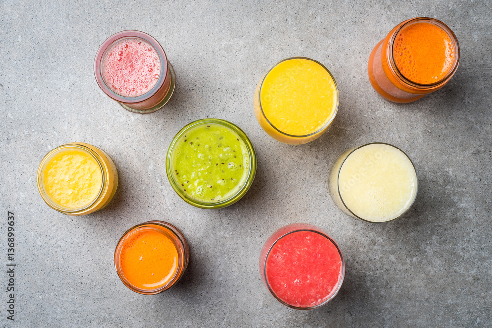 Glasses of fresh juice on gray stone table. Food background Glasses of fresh juice on gray stone table. Food background