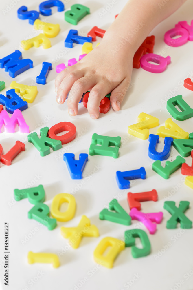 Naklejka premium Little girl learning to read using magnetic letters. Learn Study Education School Knowledge Concept