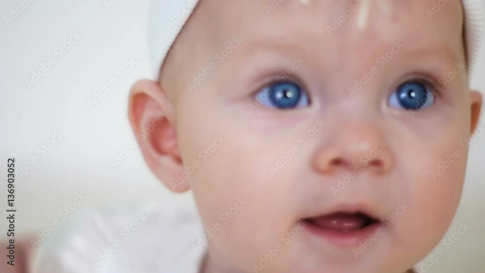 baby girl in white dress and headband sitting on a little iron bed baby girl in white dress and headband sitting on a little iron bed