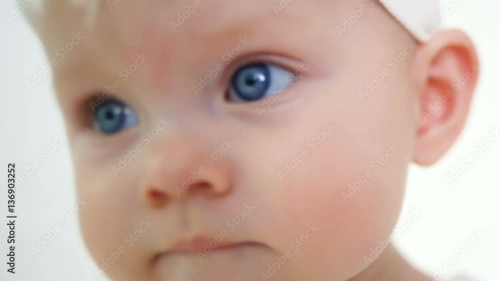 baby girl in white dress and headband sitting on a little iron bed baby girl in white dress and headband sitting on a little iron bed