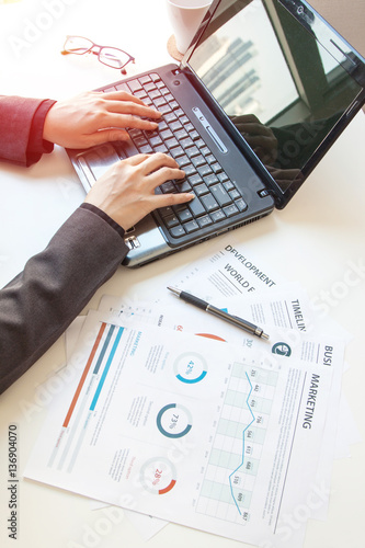 business documents on office table with laptop computer and graph financial diagram and Business people working at office