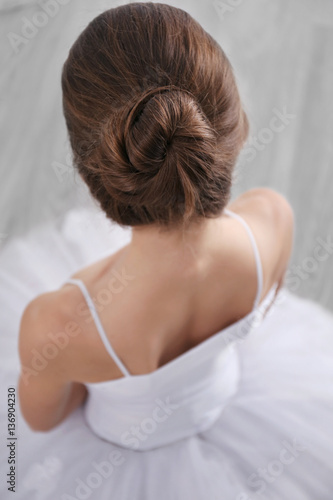 Little ballerina sitting back on floor, top view