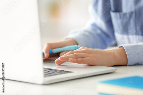 Young woman working in office with laptop  closeup