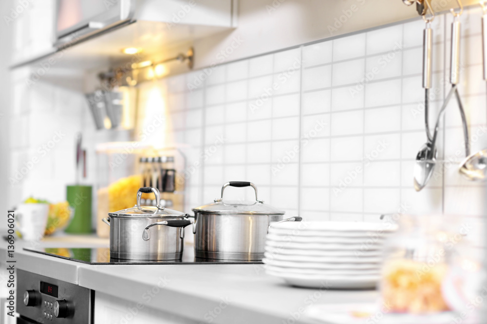 Metallic saucepans in modern kitchen interior Metallic saucepans in modern kitchen interior