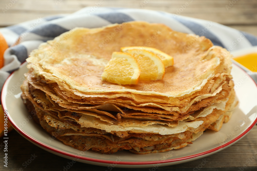 Stack of delicious pancakes with orange on wooden table Stack of delicious pancakes with orange on wooden table