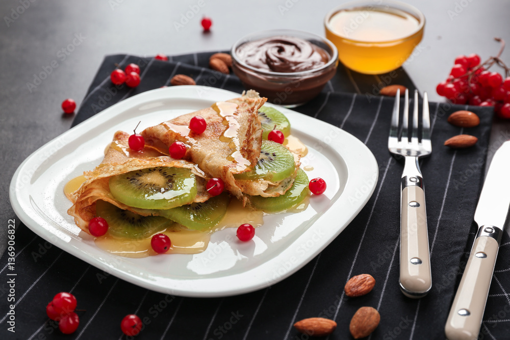 Delicious pancakes with kiwi and viburnum on white plate Delicious pancakes with kiwi and viburnum on white plate