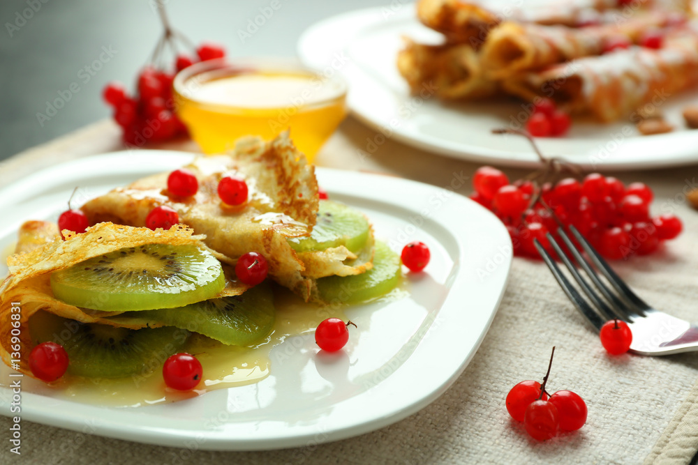 Delicious pancakes with kiwi and viburnum on white plate Delicious pancakes with kiwi and viburnum on white plate