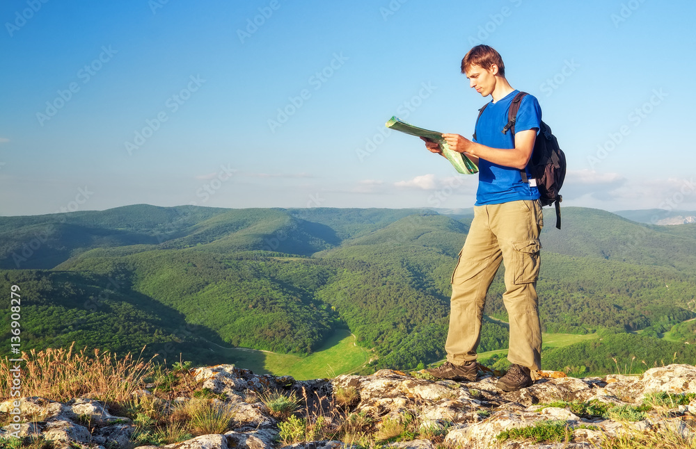 Man tourist in mountain read the map. Man on top of mountain. To Man tourist in mountain read the map. Man on top of mountain. To