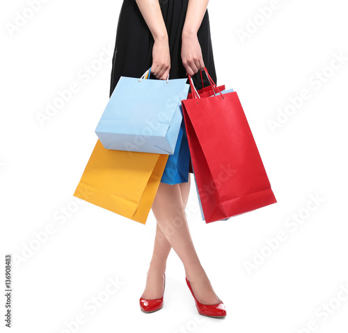 Woman's legs and shopping bags on light background