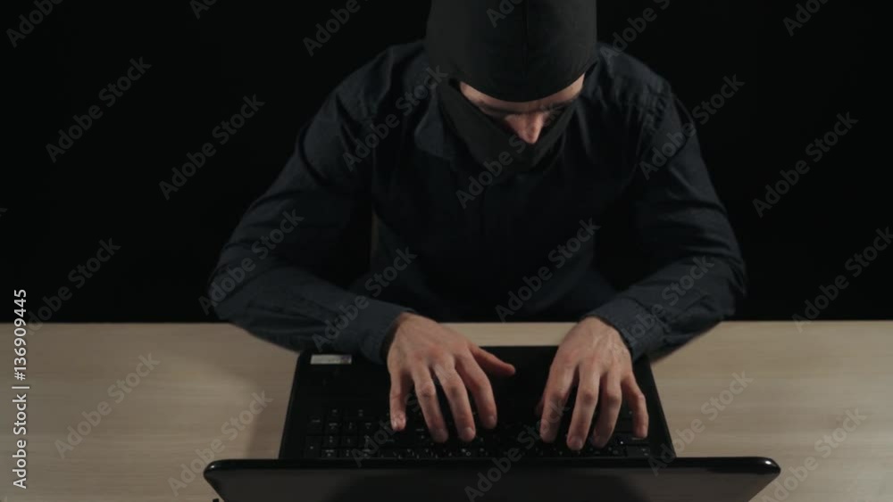 Hacker. Anonymous man in balaclava helmet typing at the computer, black background. Camera movement. 4k footage. Close-up.
Hacker. Anonymous man in balaclava helmet typing at the computer, black background. Camera movement. 4k footage. Close-up.