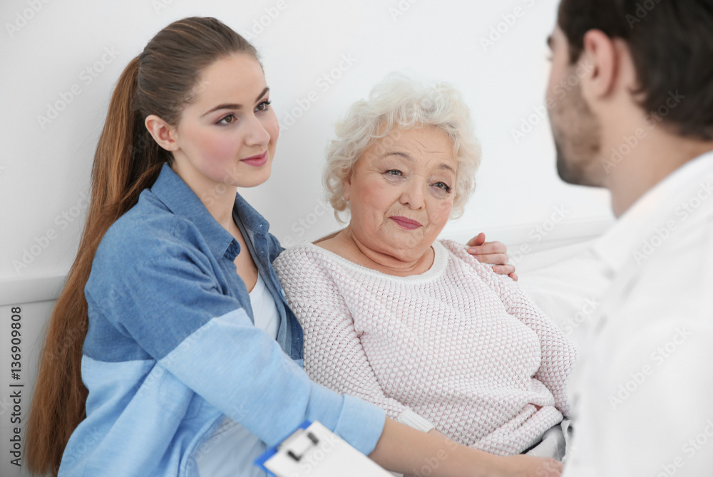 Fototapeta premium Beautiful girl with grandmother visiting doctor