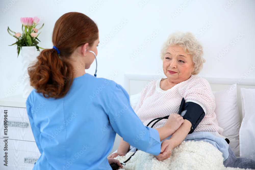 Obraz premium Measuring woman's blood pressure with tonometer